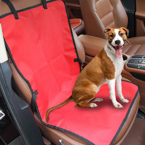 Un chien qui sort sa langue et assis sur une housse de protection de siège de voiture
