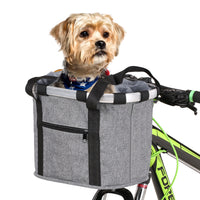 Un petit chien marron dans son panier à vélo pour chien de couleur gris