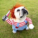 Un chien portant un déguisement chucky pour chien avec un couteau sur une pelouse.