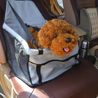 Un petit chien en peluche marron dans son panier gris attaché sur un siège de voiture
