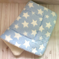 Une couverture chien, bleu étoile, plié sur une  une planché beige