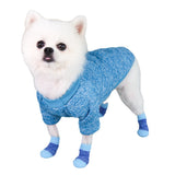 Small white dog wearing blue cotton booties and a matching sweater, paws protected and well supported, ready for a gentle walk.