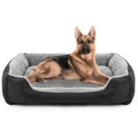 Chien de grande taille allongé confortablement dans un panier gris et noir, aux rebords rembourrés et à la base moelleuse, conçu pour résister aux usages intensifs.