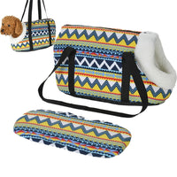Un sac avec des motifs maya, avec un petit chien dedans, et un autre sac posé avec les mêmes motifs, le tout sur un fond blanc
