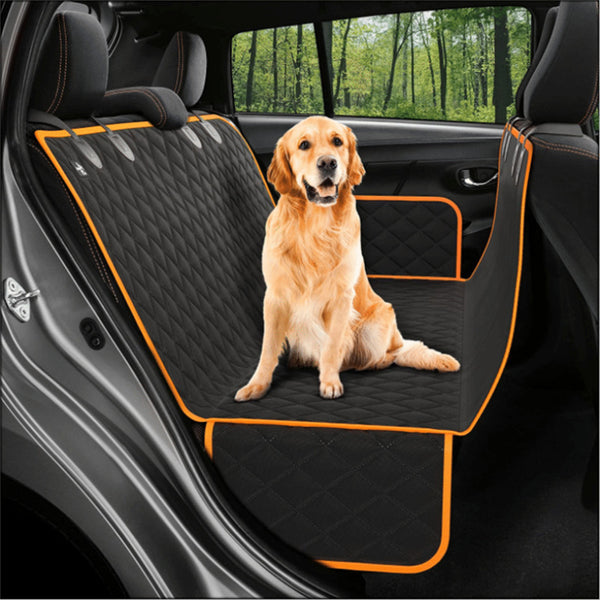 Un chien de race Golden Retriever assis sur un protège siège noir et orange pour chien dans une voiture