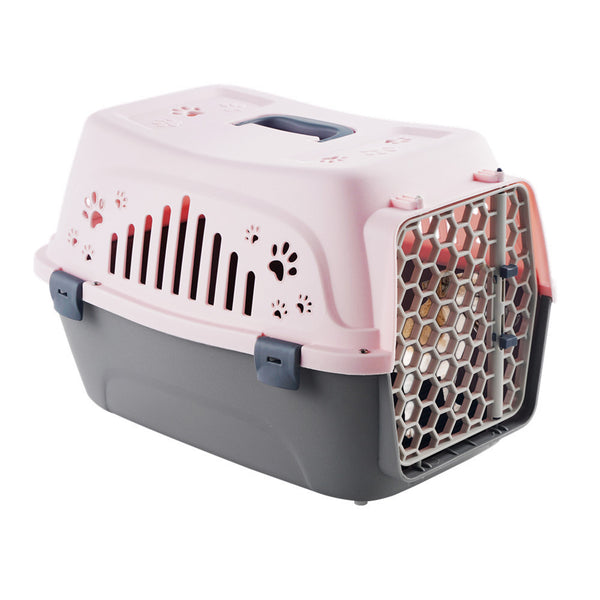 Un chien dans sa caisse de transport pour chien de couleur rose et gris sur un fond blanc