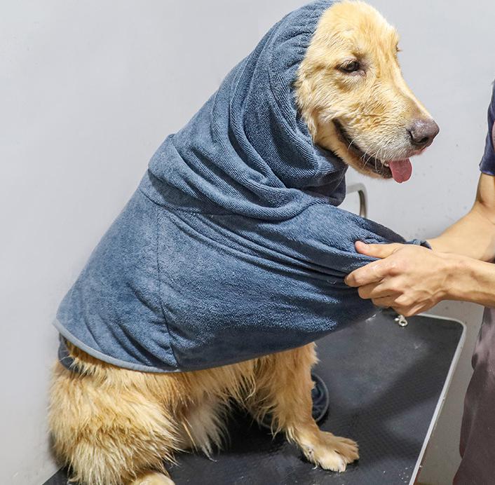 chien se faisant sécher par son maitre avec un peignoir pour chien